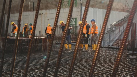 Rebar steel reinforcement at a construction site, emphasizing implementation and skilled workers in safety gear.