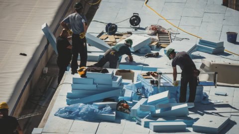 Blue foam insulation installation on roofing site during construction.