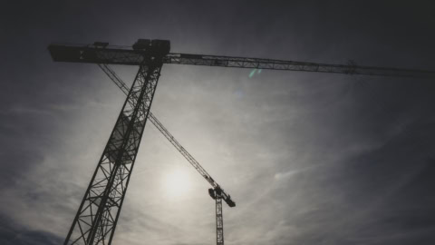 Crane silhouette against a cloudy sky, illustrating construction staging