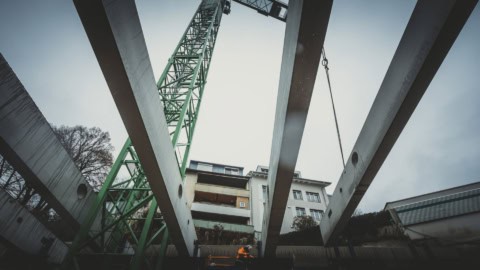 Steel beams and construction crane at a building site during structural staging phase.