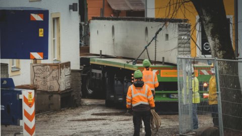 Heavy machinery and construction workers staging at a residential construction site.